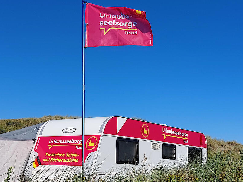 Der Wohnwagen der Urlaubsseelsorge steht in den Dünen auf Texel für die Feriengäste bereit. Foto: Stephan Hill / Bistum Essen